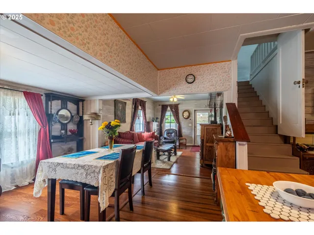 a dining hall with stainless steel appliances kitchen island granite countertop a table chairs and a refrigerator