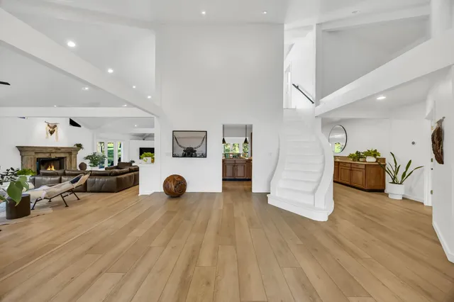 a living room with furniture a wooden floor and next to a window
