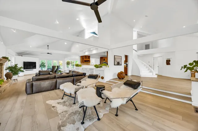 a large kitchen with a center island wooden floor stainless steel appliances and windows