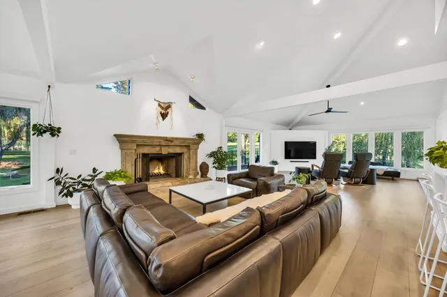 a kitchen with stainless steel appliances granite countertop a stove a sink dishwasher and white cabinets with wooden floor