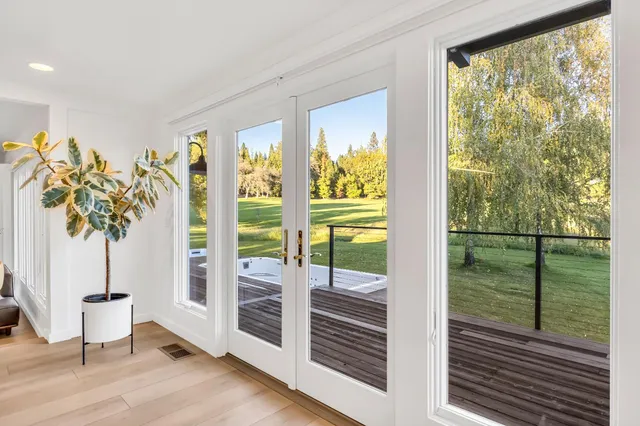 a living room with wooden floor furniture and a potted plant