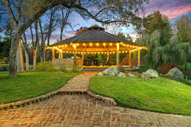 a front view of a house with a yard and trees