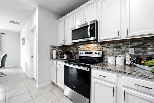 a kitchen with granite countertop stainless steel appliances and white cabinets