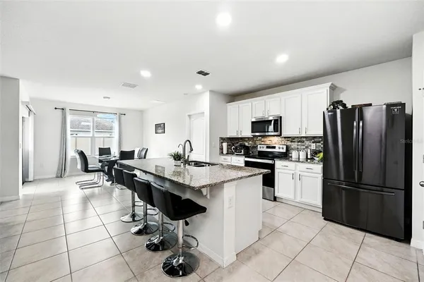 a kitchen with a sink and chairs