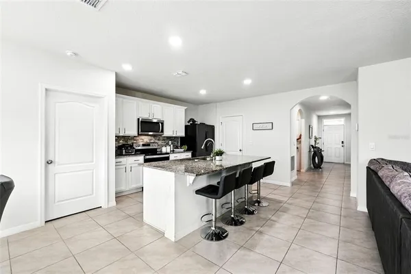a kitchen with stainless steel appliances granite countertop a sink stove and refrigerator