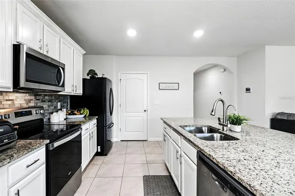 a kitchen with granite countertop a sink and a wooden floor