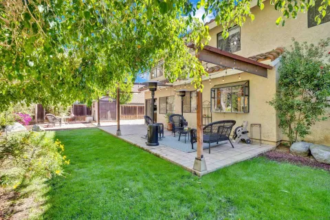a backyard of a house with table and chairs