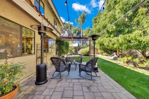 a view of a patio with table and chairs potted plants and palm trees