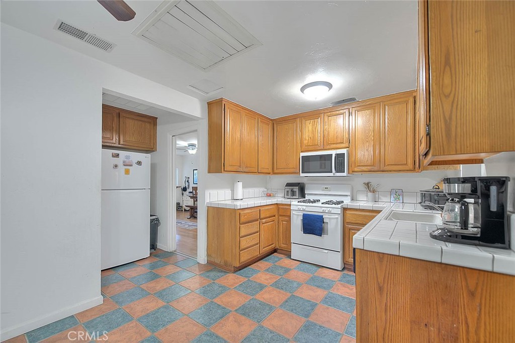 1042 Frontier Road Norco, CA 92860 - Photo 20 of 62 a kitchen with a sink a stove a refrigerator cabinets and a window
