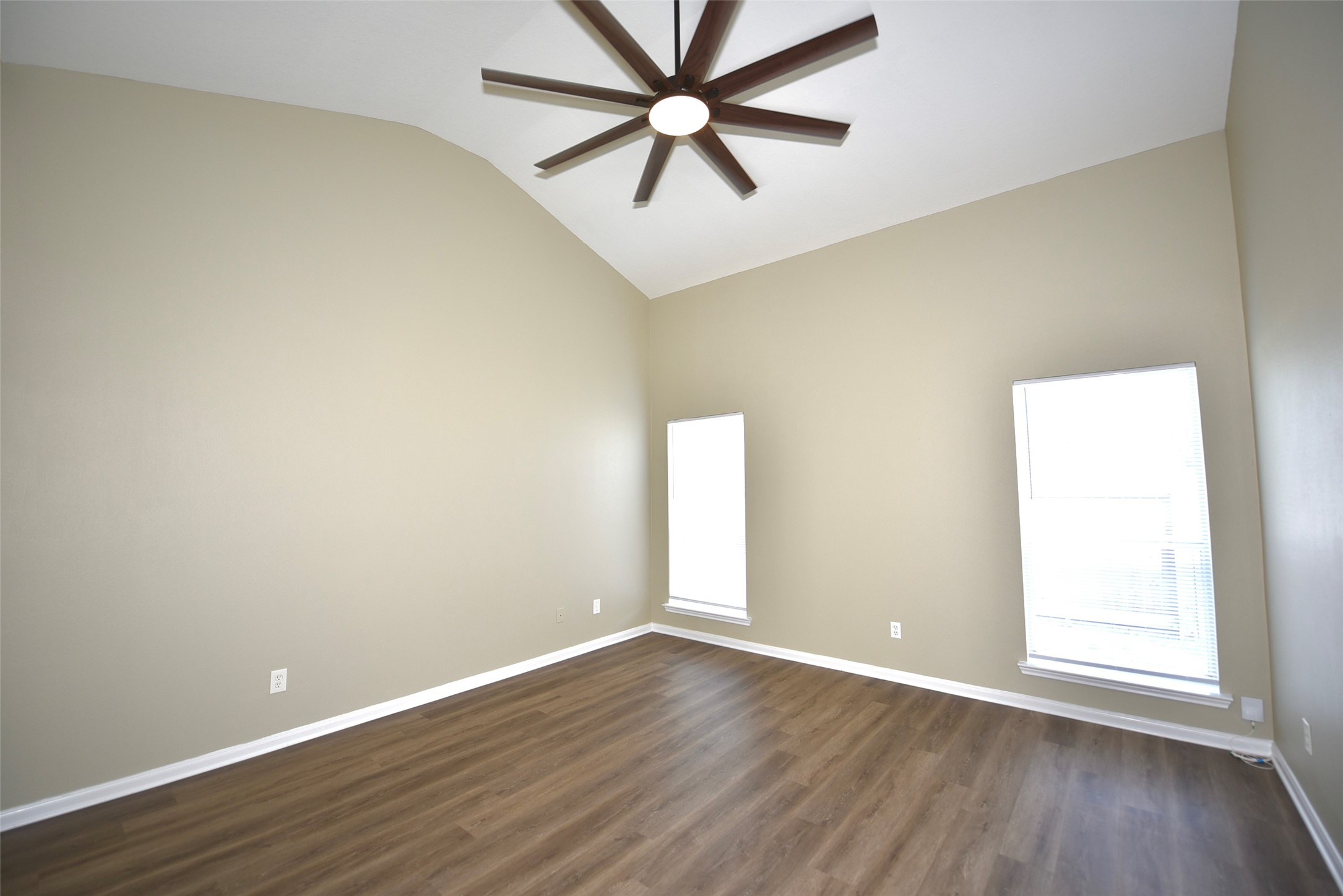 9611 Babbling Spring Court Tomball, TX 77375 - Photo 15 of 31 This spacious room features high vaulted ceilings, neutral walls, and two large windows that let in ample natural light. It has stylish wood-look flooring and a modern ceiling fan for comfort and elegance.
