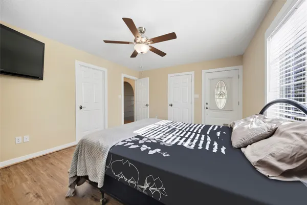 a bedroom with a large bed chandelier and a window