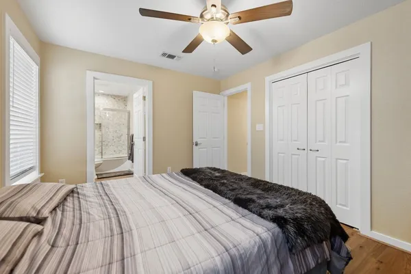 a bedroom with a large bed and a chandelier