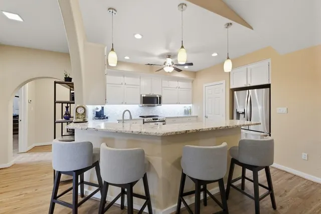 a bathroom with a granite countertop sink and a large mirror