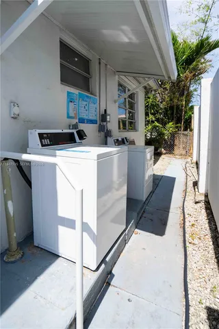 a kitchen with kitchen island a stove a refrigerator a sink dishwasher with a dining table and chairs with wooden floor