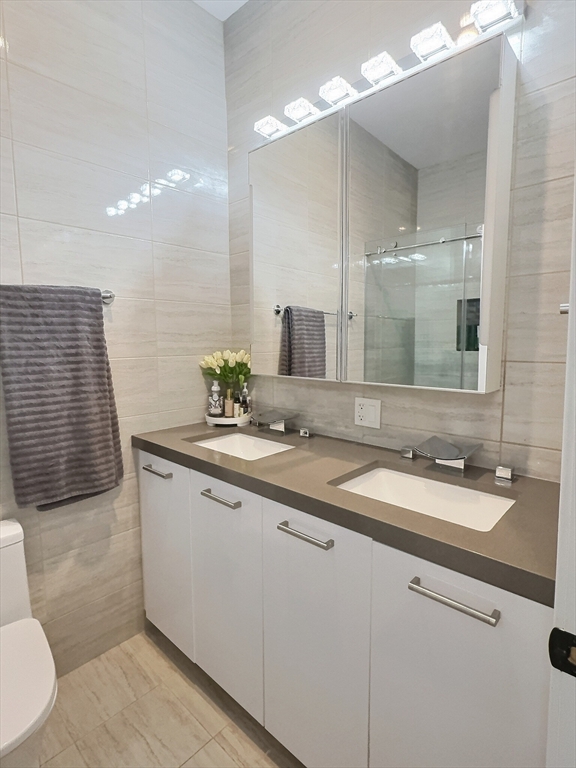 187 London Street, Unit 1 Boston, MA 02128 - Photo 12 of 26 a bathroom with a double vanity sink and a mirror