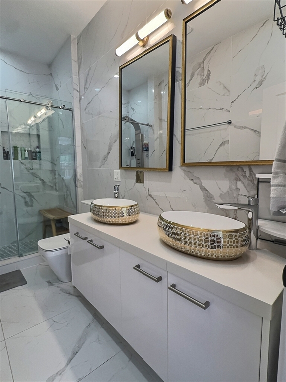 187 London Street, Unit 1 Boston, MA 02128 - Photo 14 of 26 a bathroom with a granite countertop sink a mirror and a shower