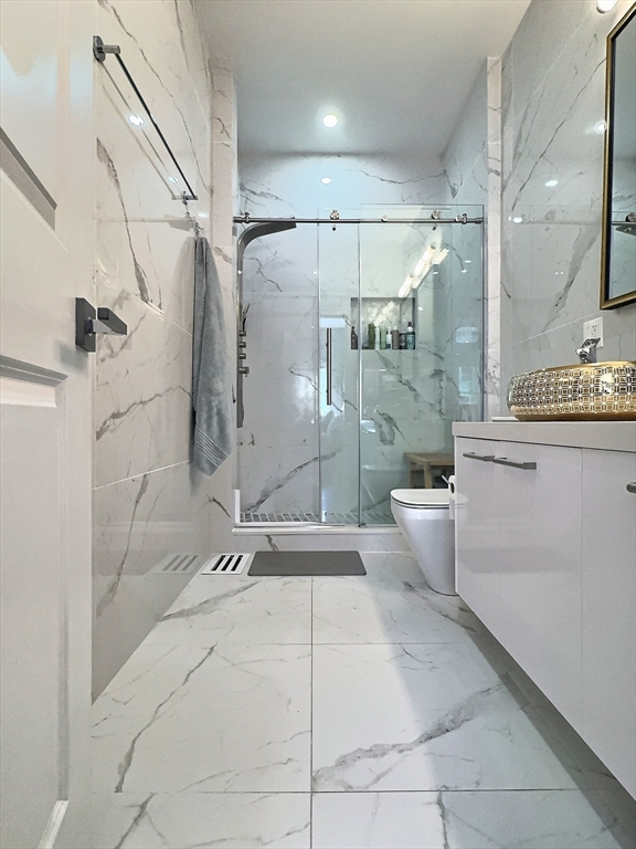 187 London Street, Unit 1 Boston, MA 02128 - Photo 15 of 26 a bathroom with a toilet a sink and shower