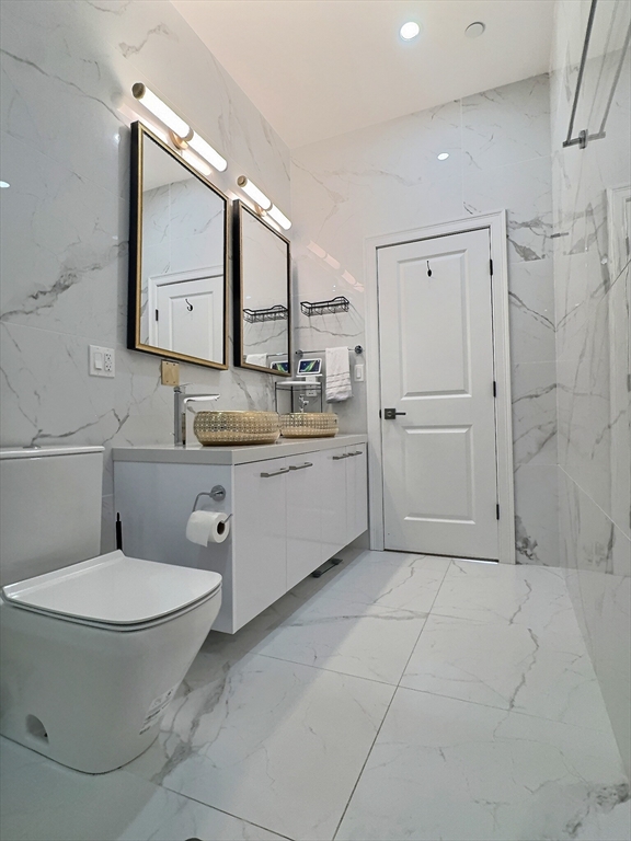 187 London Street, Unit 1 Boston, MA 02128 - Photo 16 of 26 a bathroom with a toilet sink and mirror