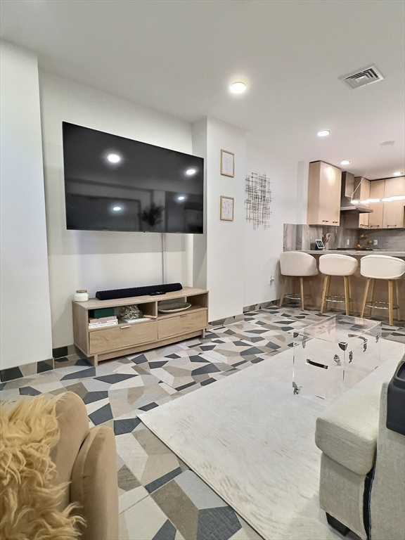 187 London Street, Unit 1 Boston, MA 02128 - Photo 19 of 26 a living room with furniture and a flat screen tv