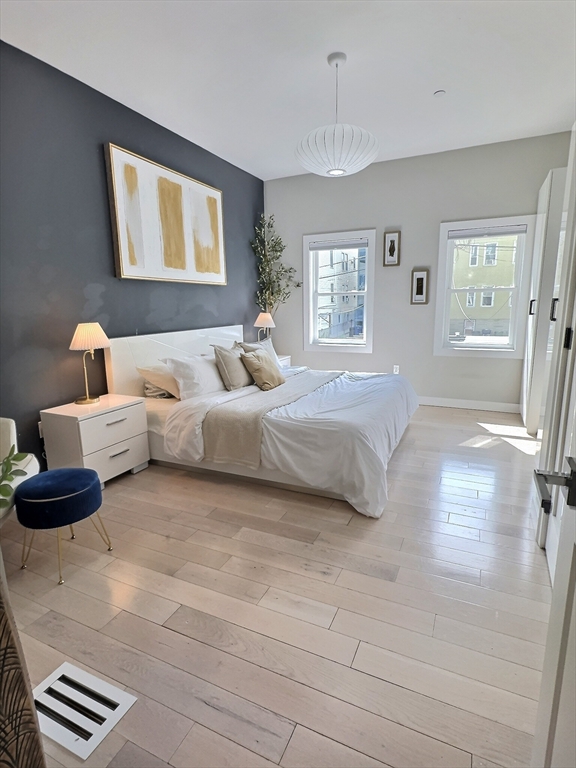 187 London Street, Unit 1 Boston, MA 02128 - Photo 2 of 26 a bedroom with a bed and wooden floor