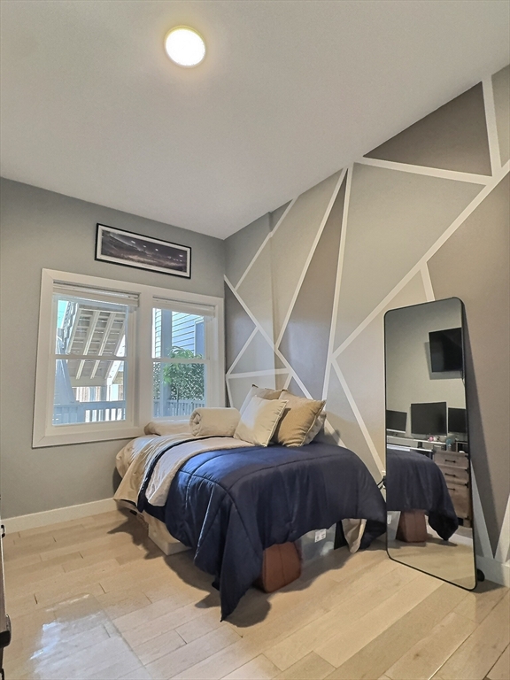 187 London Street, Unit 1 Boston, MA 02128 - Photo 7 of 26 a bedroom with a bed and a painting on the wall