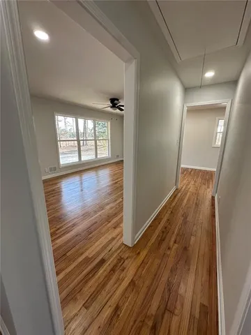 en empty room with wooden floor and windows