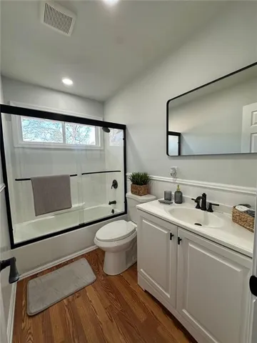 a bathroom with a toilet sink a mirror and vanity