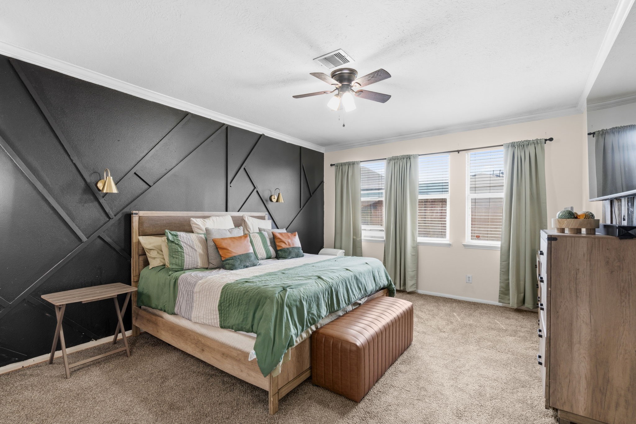 1319 Collier Point Lane Fresno, TX 77545 - Photo 15 of 33 The serene primary suite offers a peaceful retreat with generous space, large windows, and a striking designer accent wall that adds modern character.