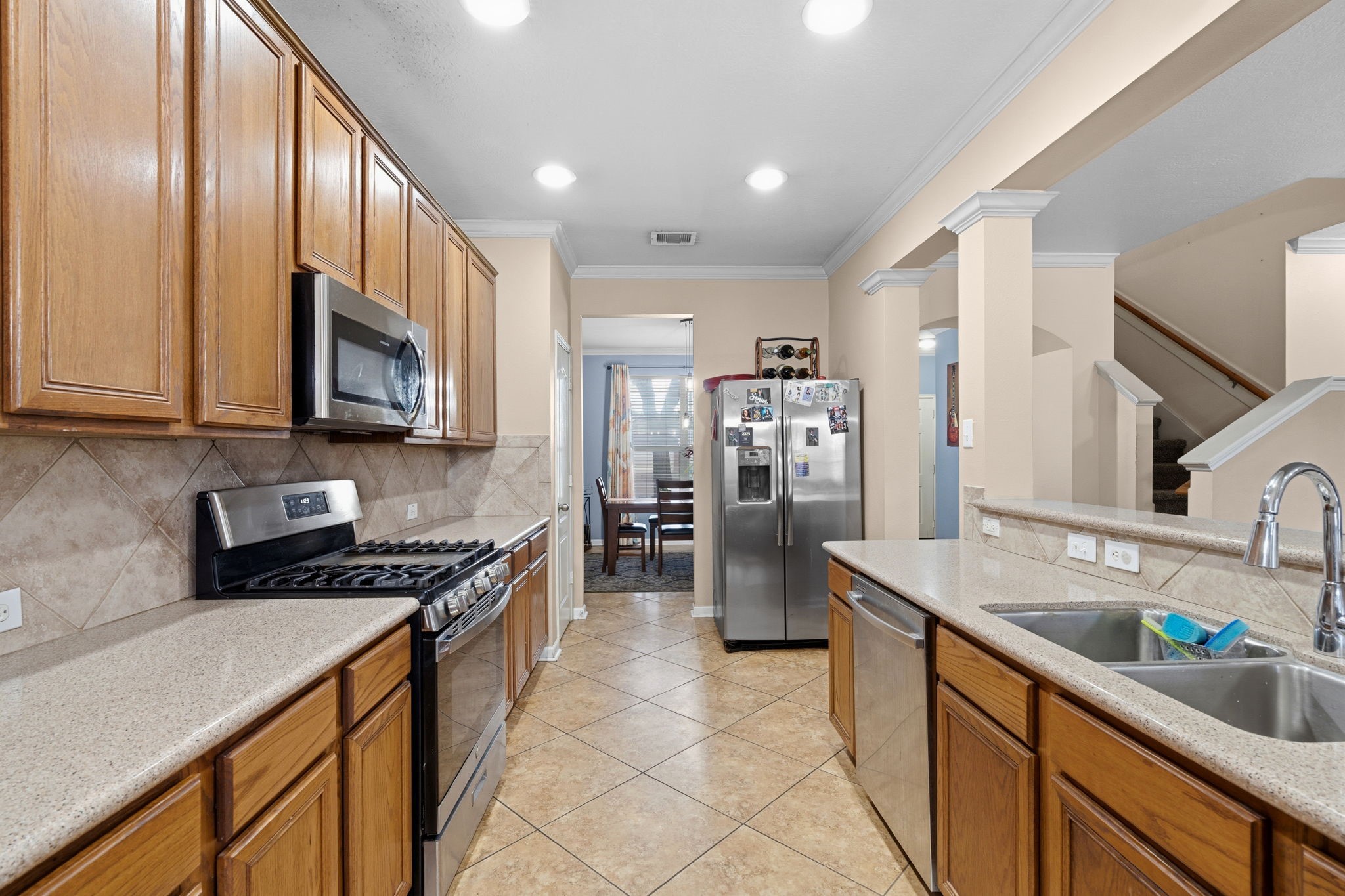 1319 Collier Point Lane Fresno, TX 77545 - Photo 7 of 33 a kitchen with stainless steel appliances granite countertop a sink stove and refrigerator