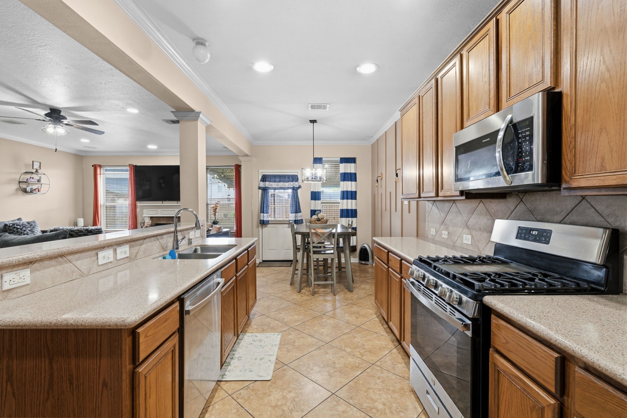 1319 Collier Point Lane Fresno, TX 77545 - Photo 8 of 33 a kitchen with stainless steel appliances granite countertop a stove top oven a sink a dining table and chairs with wooden floor
