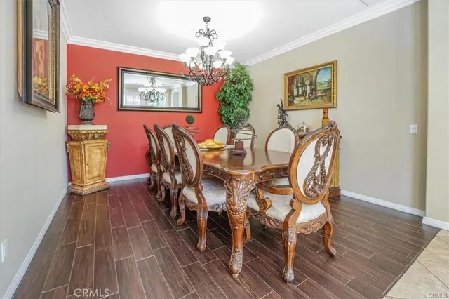 a view of a dining room with furniture a chandelier and wooden floor