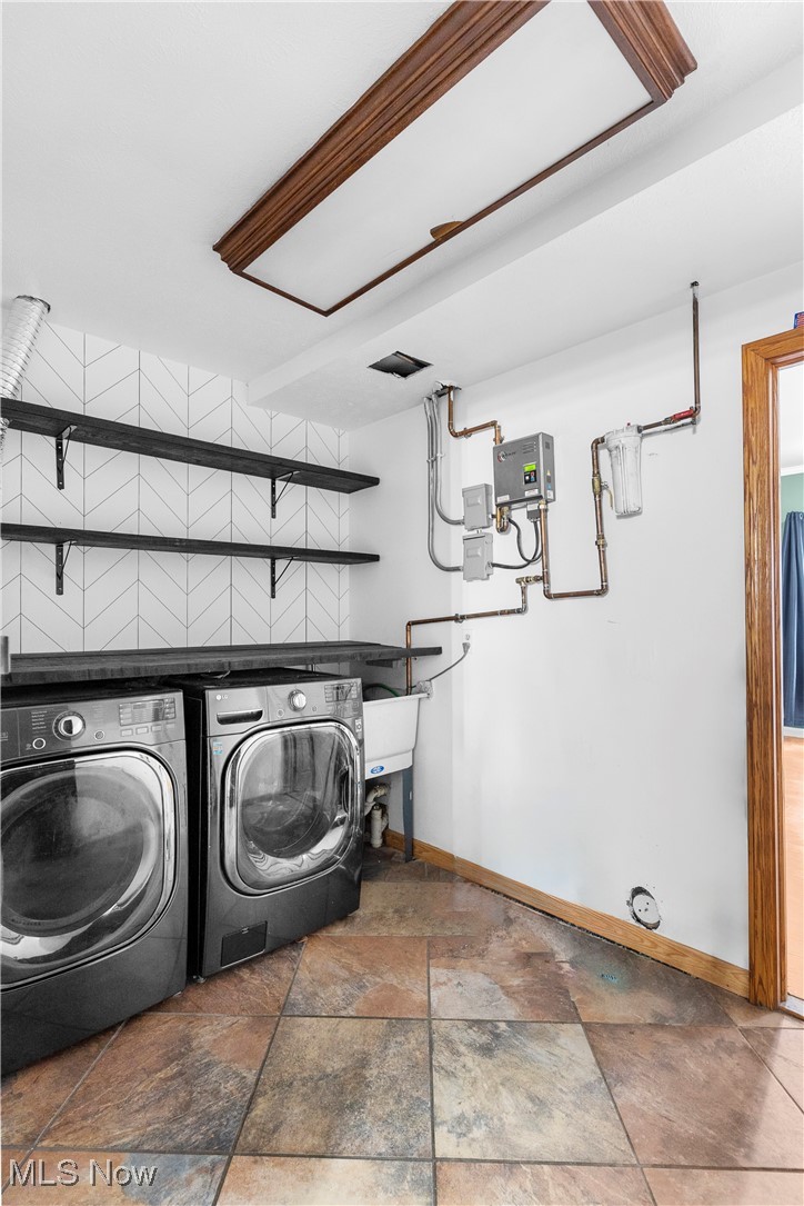 4075 Kirk Road Austintown, OH 44511 - Photo 23 of 40 Clothes washing area with washing machine and clothes dryer, stone finish floor, and baseboards