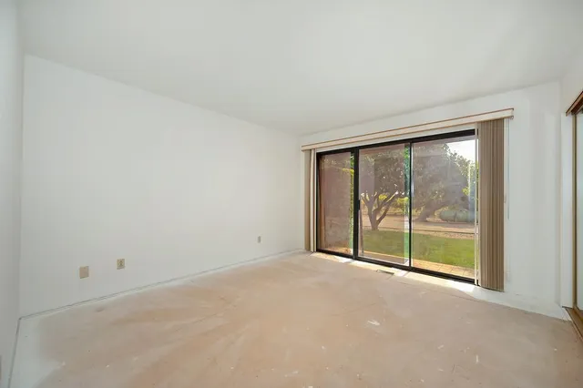 a view of a big room with windows and chandelier fan