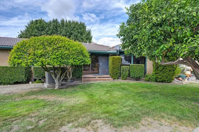 an aerial view of a house with a garden and lake view