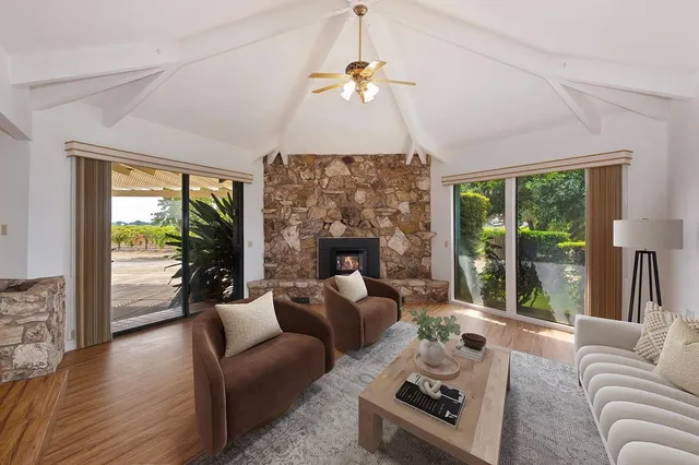 a view of an empty room with wooden floor fireplace and a window