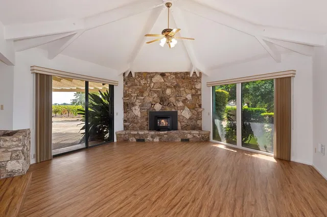 a view of a hall with wooden floor and floor to ceiling window