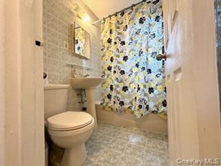 67-20 218th Street, Unit LOWR Queens, NY 11364 - Photo 7 of 17 Bathroom featuring tile walls and shower / bath combination with curtain