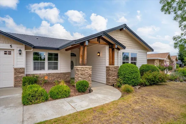 a front view of a house with a yard and potted plants
