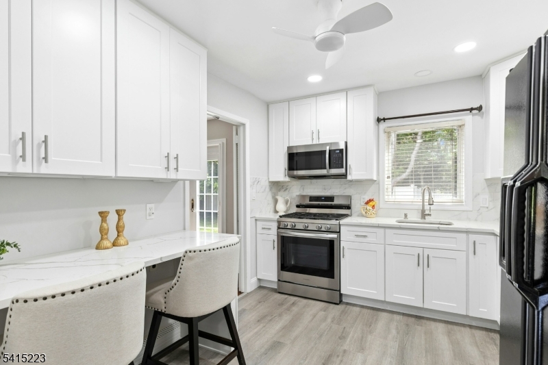 33 Carol Road Westfield, NJ 07090 - Photo 12 of 23 a kitchen with stainless steel appliances granite countertop a stove a sink and a refrigerator