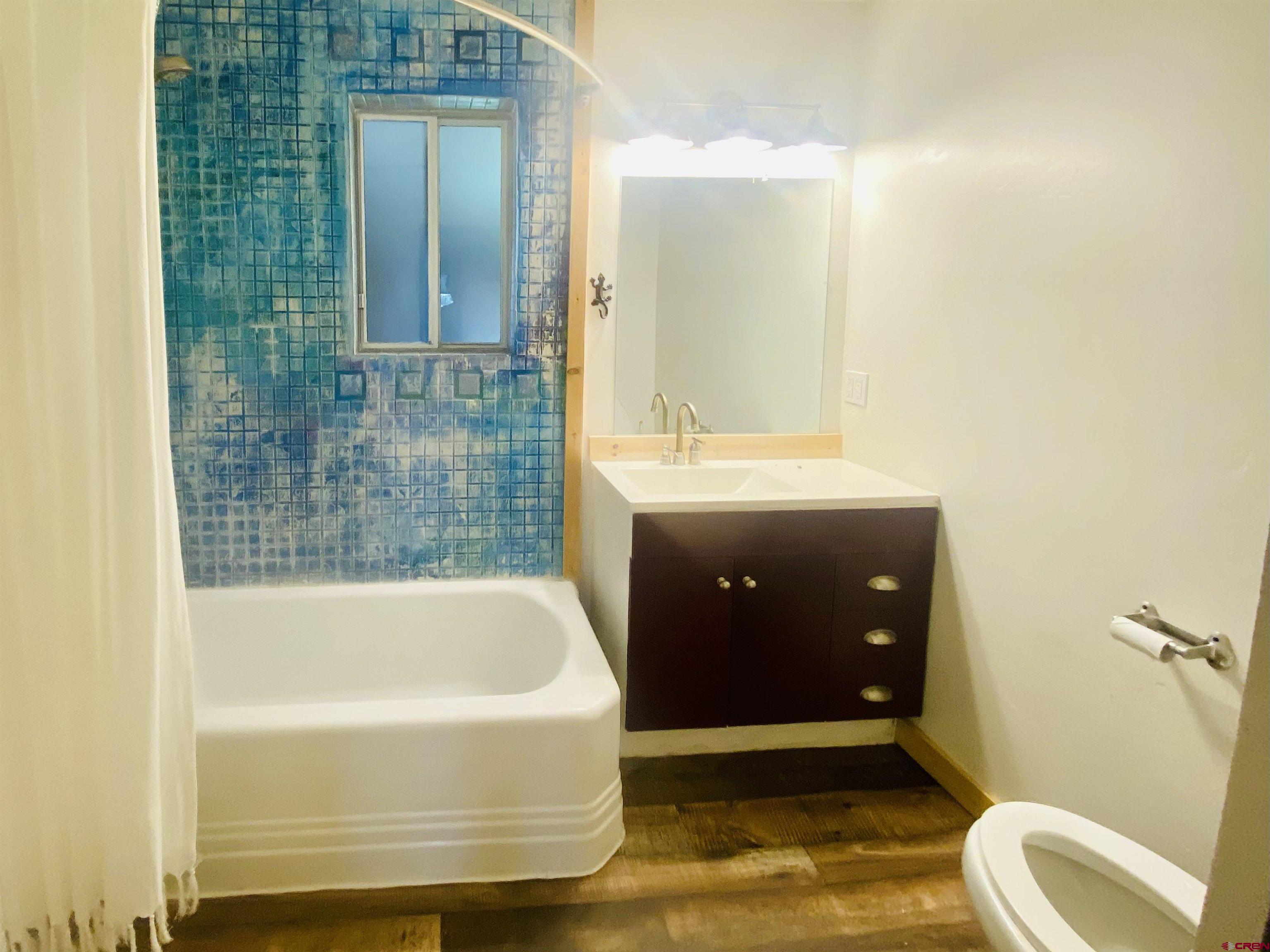 646 Riverside Avenue Mancos, CO 81328 - Photo 18 of 36 a bathroom with a tub a sink and mirror