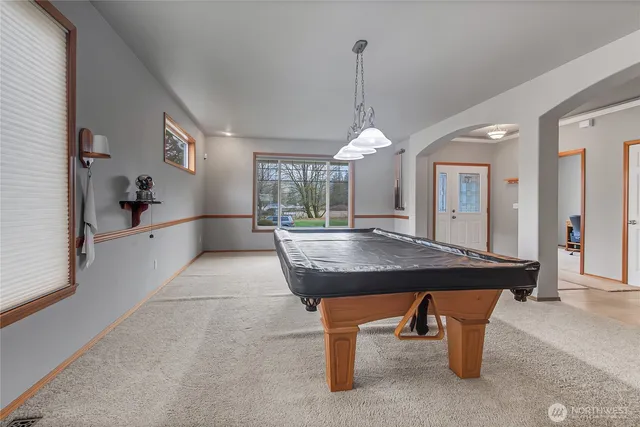 a room with pool table and windows