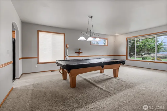 a room with pool table and windows