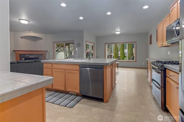 a kitchen with stainless steel appliances granite countertop a stove a sink dishwasher and a refrigerator