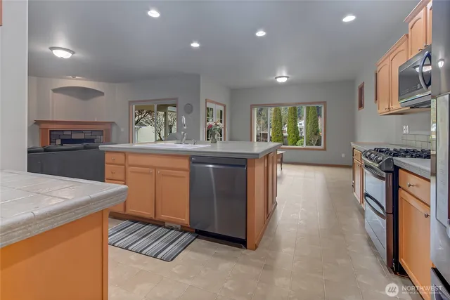 a kitchen with stainless steel appliances granite countertop a stove a sink dishwasher and a refrigerator