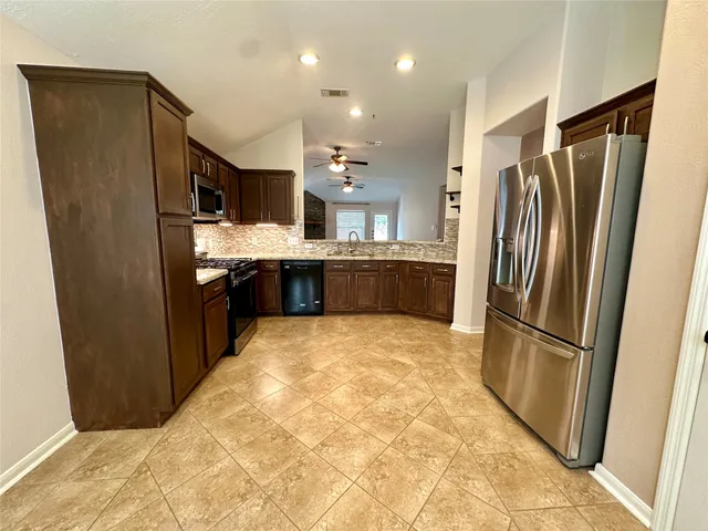 a large kitchen with a refrigerator and a sink