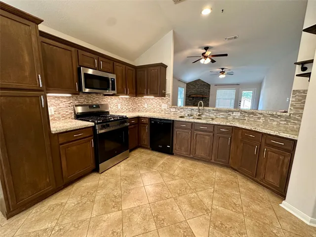 a kitchen with stainless steel appliances granite countertop a sink and a stove