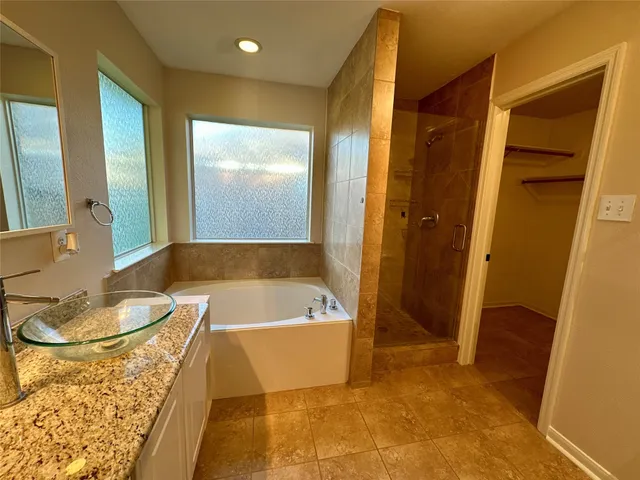 a bathroom with a tub a sink and a mirror