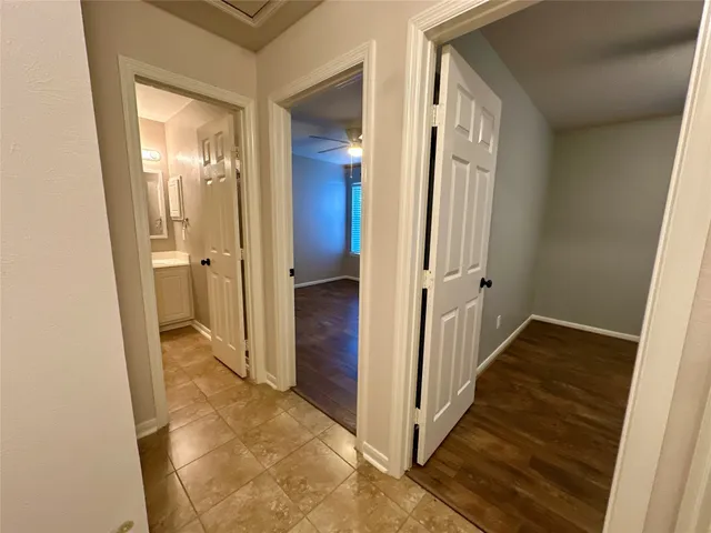 an empty room with a window and chandelier fan