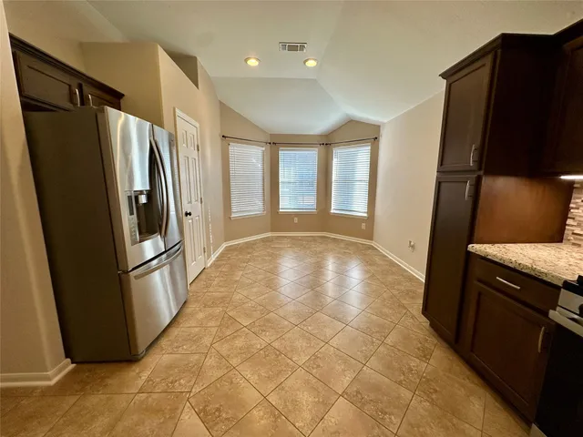 a view of a refrigerator in kitchen and wooden floor