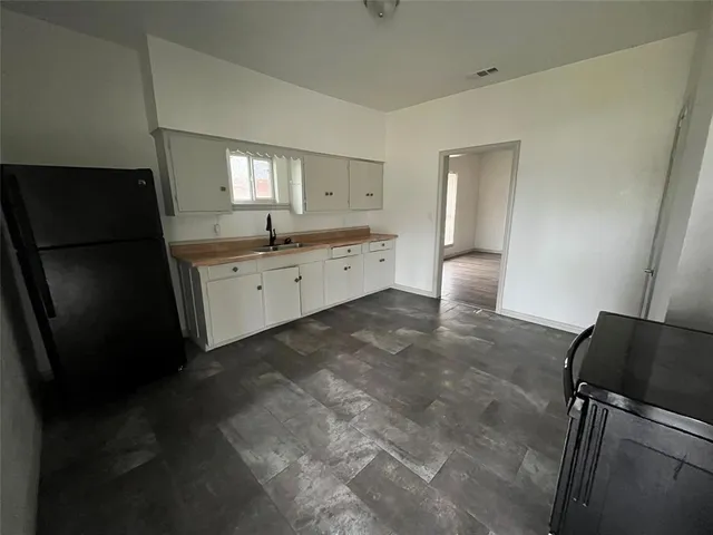 a large kitchen with a refrigerator a sink dishwasher and a stove